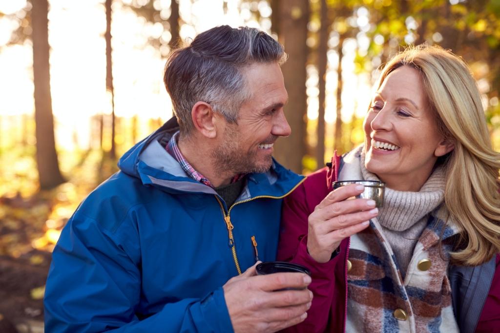 Mature Retired Couple Stop For Rest And Hot Drink On Walk Through Fall Or Winter Countryside