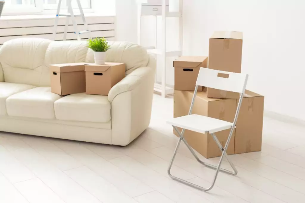 Folding chair sofa and boxes are in the new living room when residents move to a new apartment. The